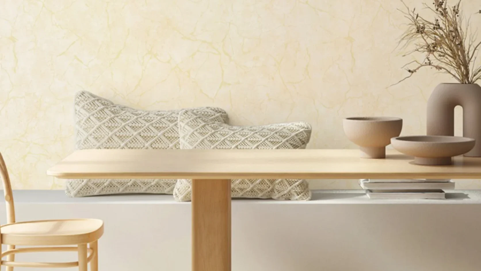 Minimalist timber dining table and banquette against MIRA 42-inch Ivory Cream Kintsugi Gold Marble wallpaper (NQH728702) and chevron wood flooring.